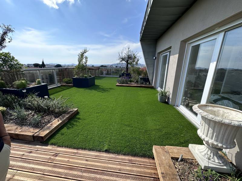  Aménagement d'un toit terrasse en ville avec terrasse en bois, pelouse synthétique et spa