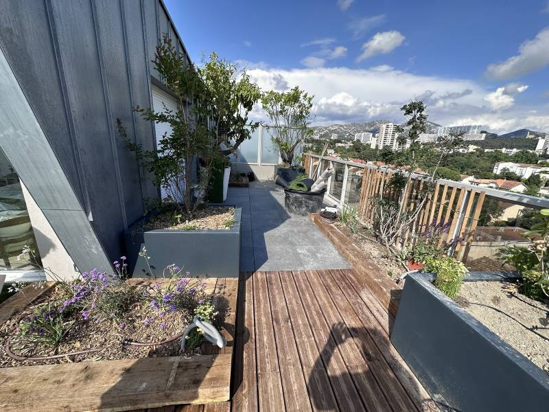  Aménagement d'un toit terrasse en ville avec terrasse en bois, pelouse synthétique et spa