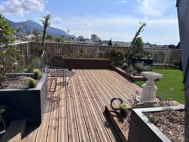  Aménagement d'un toit terrasse en ville avec terrasse en bois, pelouse synthétique et spa